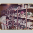 Man standing by product display shelves (ddr-densho-426-1229)