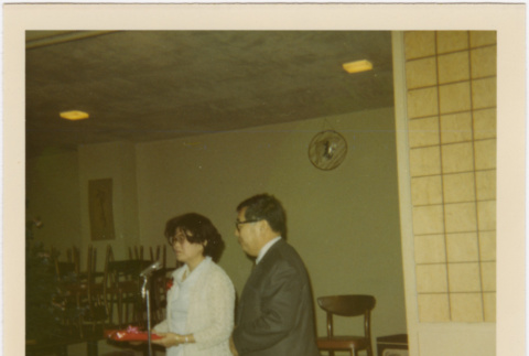 Tomoye and Henri Takahashi standing at microphone (ddr-densho-426-164)