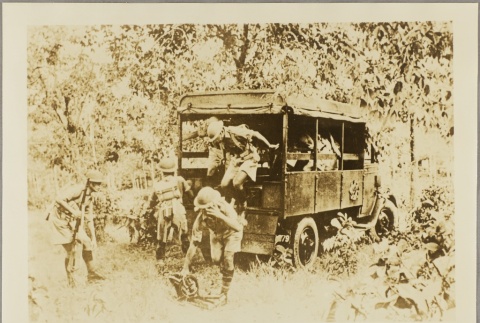 Singaporean soldiers climbing out of a covered truck bed (ddr-njpa-13-1135)