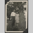 Man and woman standing near a tree (ddr-manz-10-124)