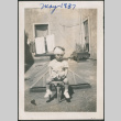 Child sitting on stool holding a ball (ddr-densho-483-691)