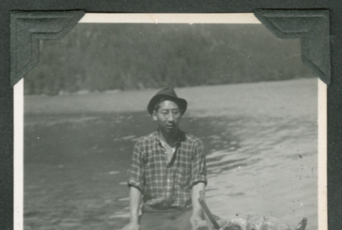 Man sitting near wood debris (ddr-densho-540-76)