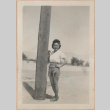 Woman standing next to a telephone pole (ddr-manz-10-68)