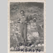 Man leaning against wire fence (ddr-densho-466-274)