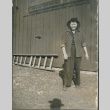A woman standing in front of a barn (ddr-densho-201-1008)