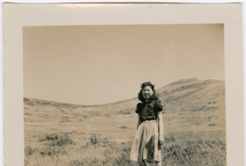 Tomoye (Nozawa) Takahashi standing in a field (ddr-densho-426-1941)