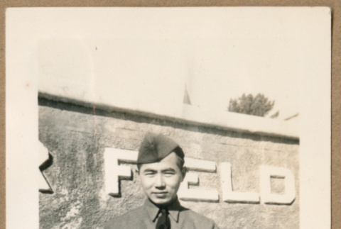 Japanese American soldier poses in front of sign (ddr-densho-368-491)