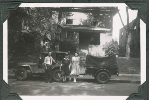 Photo of a family of three in front of a jeep with a trailer (ddr-densho-483-381)