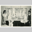 Photograph of two girls standing in front of a display of stencil decorated items (ddr-csujad-47-70)
