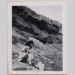 Woman sitting on boulder by hillside (ddr-densho-464-48)
