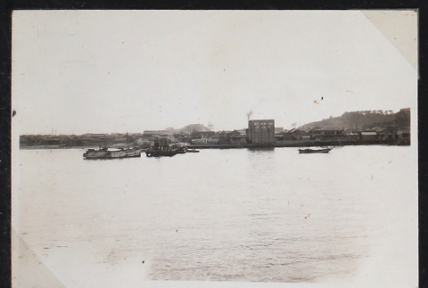 Boats float near a harbor town (ddr-densho-404-6)