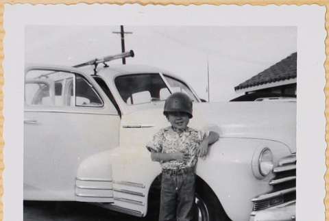 William Shiomi by car in combat helmet (ddr-densho-522-221)