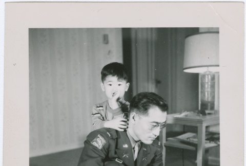 A serviceman kneeling with a boy (ddr-densho-338-5)