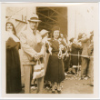 Man and woman standing on dock, holding streamers (ddr-densho-426-1677)