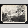 Man poses across a fallen tree (ddr-densho-542-754)
