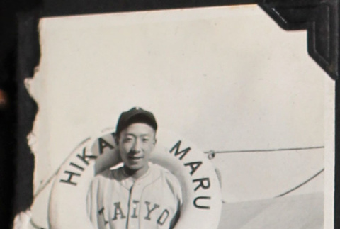 Man with life ring on board ship, wearing baseball uniform (ddr-densho-326-365)