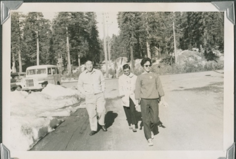 Three people walking towards the  camera (ddr-densho-321-461)