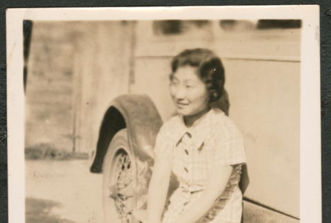 Woman sitting on running board of a car (ddr-densho-433-792)