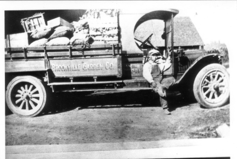 Young man sitting on a truck (ddr-densho-109-36)