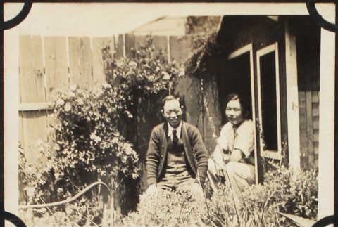 Two men sitting outside shed in garden (ddr-densho-423-518)