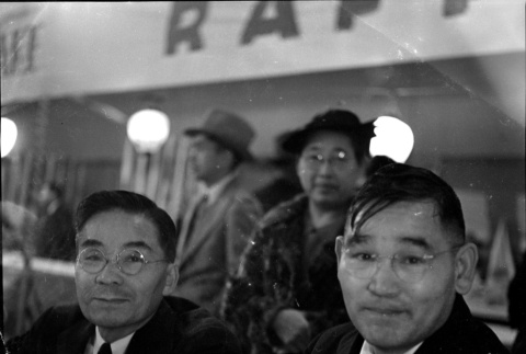Two men sitting at counter, woman standing behind them (ddr-densho-426-1761)