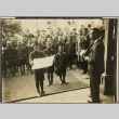 A boy reading a speech in front of men and other schoolboys (ddr-njpa-13-1189)