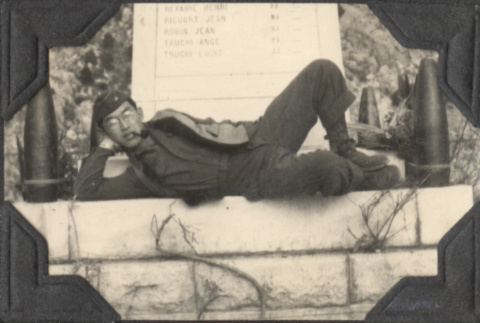 Man laying on base of monument (ddr-densho-466-939)