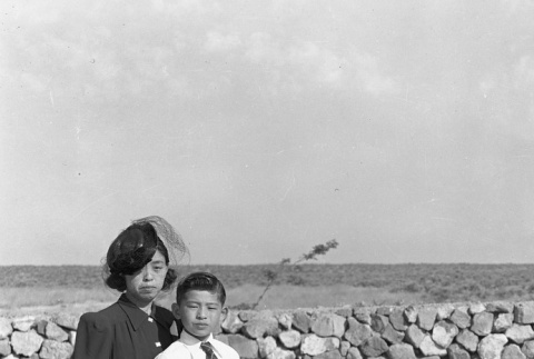 Mother and son standing next to a grave (ddr-fom-1-158)