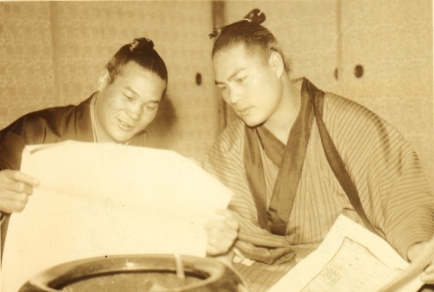 Two sumo wrestlers reading a paper (ddr-njpa-4-2047)