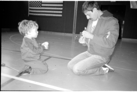 Man with child on gym floor (ddr-densho-1007-1257)