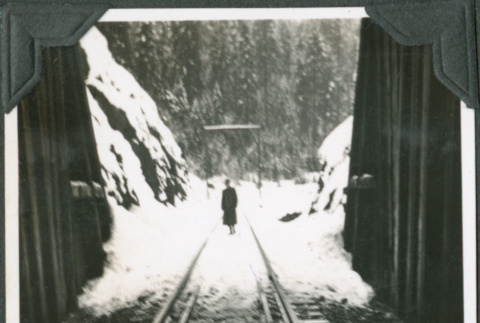 Man standing at entrance of train tunnel, taken from inside tunnel (ddr-ajah-2-315)