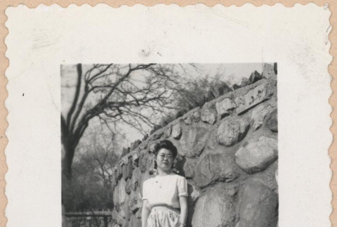 Woman standing in front of a stone wall (ddr-manz-10-79)