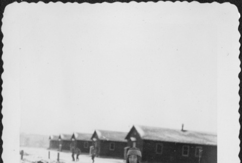 Man standing in snow outside barracks (ddr-densho-434-384)