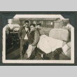 Three friends gathered around luggage (ddr-densho-550-256)