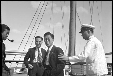 Three men and crew member on board ship (ddr-densho-426-265)