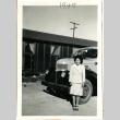 Woman standing in front of a truck (ddr-manz-6-85)