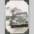 Man in uniform sitting on fender of car (ddr-ajah-2-151)