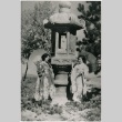 Two women pose with a stone lantern (ddr-densho-353-329)