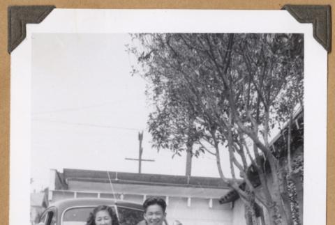 Gary Kikawa and a woman on car bumper (ddr-densho-542-79)