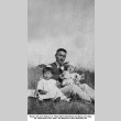 Keiji Shiota with children sitting in field (ddr-ajah-6-870)