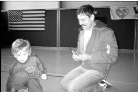 Man with child on gym floor (ddr-densho-1007-1260)