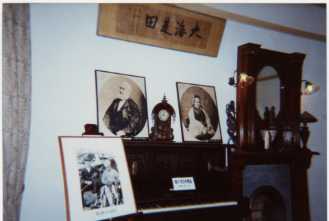 Display of photos, piano and fireplace surround (ddr-densho-426-576)