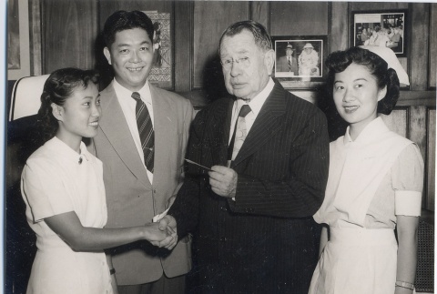 John H. Wilson posing with another man and two nurses (ddr-njpa-2-903)