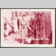 Woman with camera standing by plants (ddr-densho-534-104)