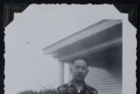 Man poses by house porch (ddr-densho-359-1516)