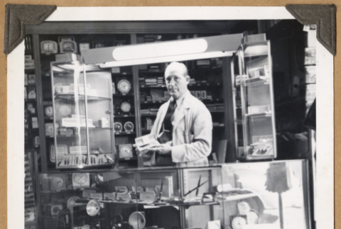 Man standing behind a display (ddr-densho-542-111)