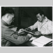 Nisei man signing enlistment papers (ddr-densho-122-759)
