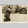 Man aiming a rifle at a truck tire (ddr-njpa-13-274)