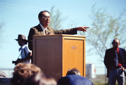 A man speaking at a remembrance program (ddr-densho-294-66)