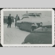 Two men shoveling ice and snow off a car (ddr-densho-321-347)
